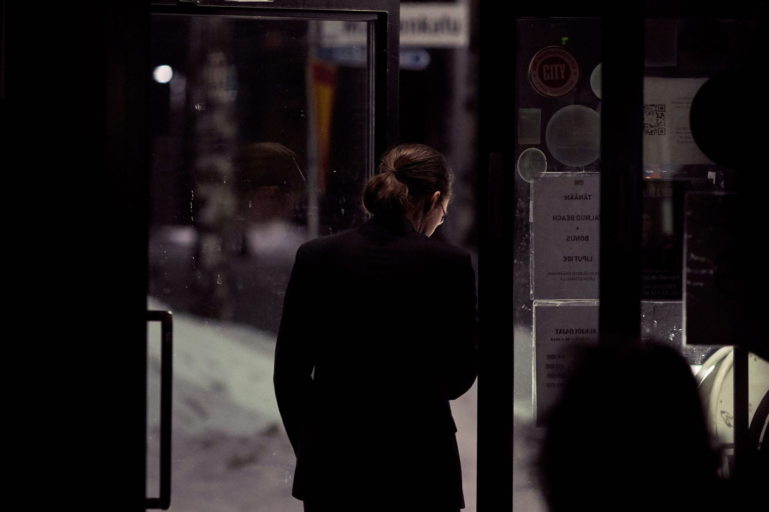 person in black top standing beside door